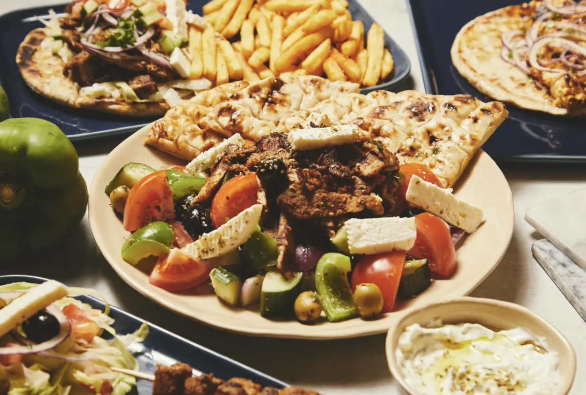 Græsk pita-tallerken med kød, salat, feta og pitabrød til en fest