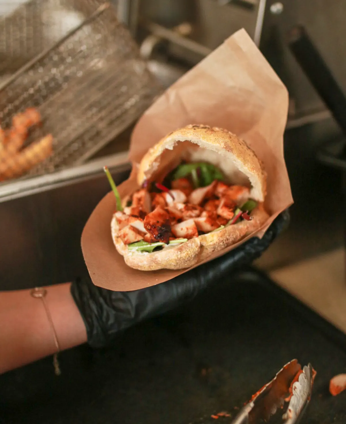 Pita med krydret kylling holdt i hånden